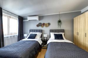 two beds sitting next to each other in a bedroom at Spacious Old Town LOFT for 6 in Bratislava