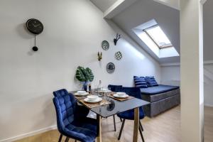 a dining room with a table and blue chairs at Spacious Old Town LOFT for 6 in Bratislava