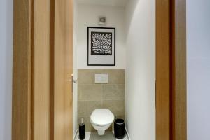 a bathroom with a toilet and a picture on the wall at Spacious Old Town LOFT for 6 in Bratislava