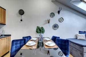 a dining room with a table and blue chairs at Spacious Old Town LOFT for 6 in Bratislava +5 photos