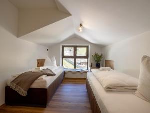 2 camas en un dormitorio con ventana en Alpine Homes - Hopfgarten, en Hopfgarten im Brixental