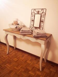 een tafel met een spiegel en een kom erop bij Residenza Esse in Angera