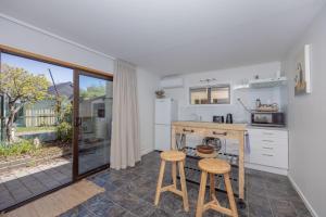 a kitchen with a counter and two stools in it at Wanaka Deluxe Studio in Wanaka
