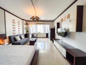 een grote woonkamer met een bank en een tv bij Nimman Lanna - The Sister's Home in Chiang Mai