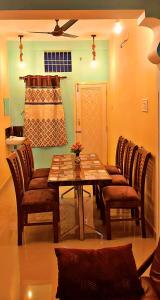 una sala da pranzo con tavolo e sedie in legno di Mahalakshmi Home Stay a Kanchipuram