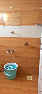 un bagno con una ciotola blu su un pavimento in legno di Mahalakshmi Home Stay a Kanchipuram