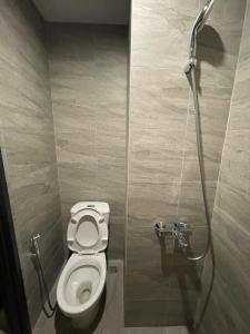 a bathroom with a toilet and a shower at The Collins Apartment in Pekoelonan