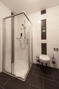a bathroom with a shower and a toilet at Hotel Am Pan in Emmerich