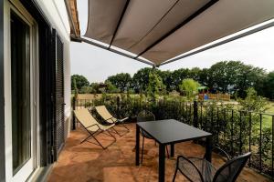 a patio with a table and chairs on a balcony at Hortus Natural Living in Todi