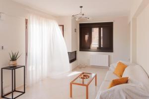 a white living room with a couch and a table at Villa GEM in Porto Rafti