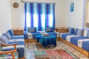 a living room with blue furniture and blue curtains at Casa Voyager 'secret garden terrace' in Chefchaouen