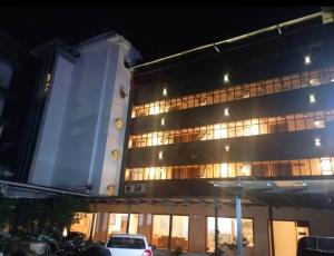 a white car parked in front of a building at night at Queens Tourist Home in Badagara