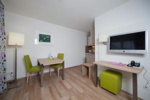 a living room with a table and green chairs at Hotel Am Pan in Emmerich