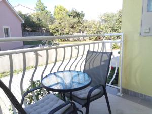 a balcony with a table and chairs on a balcony at Ana Rooms in Krk