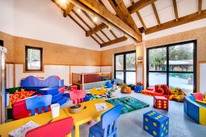 - une salle de jeux pour enfants avec une table et des chaises dans l'établissement Village Club Les Tavaillons, aux Carroz d'Arâches