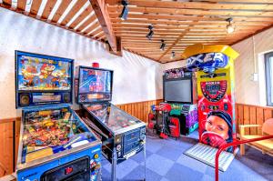 a room with two arcade games and a tv at Village Club Les Tavaillons in Les Carroz d'Araches