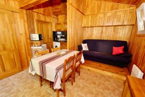 a dining room with a table and a couch in a room at Les Chalets Cobadena-Borda Pays Basque in Mouguerre