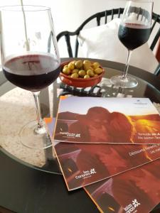 a table with two glasses of wine and a magazine at THE HAPPINESS PENTHOUSE Dream Holiday at 100m Beach! in Candelaria