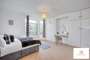 1 dormitorio con cama, escritorio y silla en Bridgwater Bliss: 6-Bedroom Haven for Large Groups, en Bridgwater