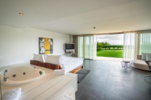 uma ampla sala de estar com uma banheira e um sofá em Kuum Hotel & Spa em Golturkbuku