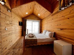 Maya World Didyma Hotel في ديديم: غرفة نوم بسرير في غرفة خشبية