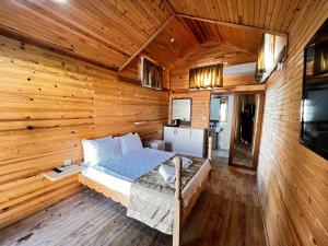1 dormitorio con 1 cama en una cabaña de madera en Maya World Didyma Hotel, en Didim