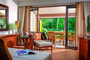 a living room with a patio with a table and chairs at Paradox Resort Phuket in Karon Beach