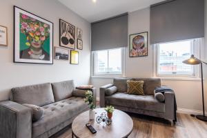 a living room with a couch and a table at 6-Bedroom Apartments at the Heart of Nottingham in Nottingham