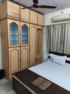 a bedroom with a bed and a cupboard at A & P Apartments in Thane