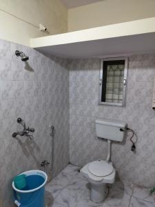 La salle de bains est pourvue de toilettes, d'une fenêtre et d'une douche. dans l'établissement A & P Apartments, à Thane