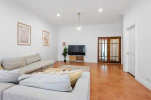 a living room with a couch and a tv at Super House, Super Host in Kalgoorlie