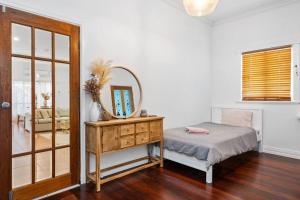 1 dormitorio con cama y tocador con espejo en Super House, Super Host, en Kalgoorlie