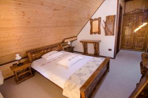 een slaapkamer met een bed in een houten hut bij Casa Bălan in Fundăţica