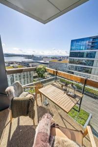 奧斯陸的住宿－Modern 2bed room sea view apartment @ Oslo Barcode，市景阳台配有桌椅。