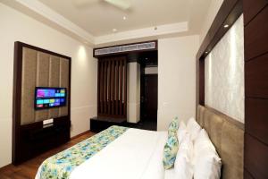a bedroom with a bed and a flat screen tv at The Stella Hotel & Resort in Ludhiana