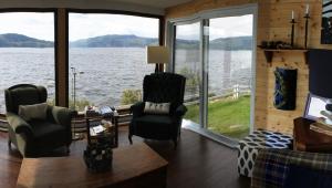 a living room with a view of a lake at Chalet La Caille in LʼAnse-Saint-Jean