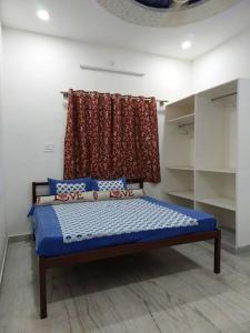 a bedroom with a bed with a curtain on the wall at Entire Villa in Jodhpur