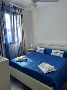 a bedroom with a blue bed with two towels on it at Villa con piscina riscaldata ad uso esclusivo, aperta tutto l'anno in Lascari