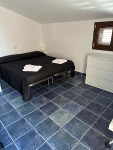 a room with a bed on a blue tiled floor at Villa con piscina riscaldata ad uso esclusivo, aperta tutto l'anno in Lascari