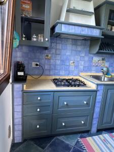 a blue kitchen with a stove and a sink at Villa con piscina riscaldata ad uso esclusivo, aperta tutto l'anno in Lascari