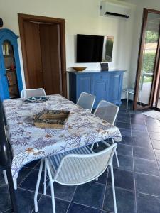 a table and chairs with a table and a tv at Villa con piscina riscaldata ad uso esclusivo, aperta tutto l'anno in Lascari