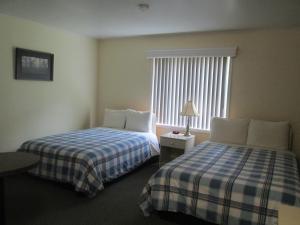 a hotel room with two beds and a window at Edgewater Motel and Campground in Temiskaming Shores