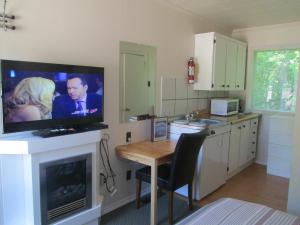 a kitchen with a flat screen tv on a fireplace at Edgewater Motel and Campground in Temiskaming Shores