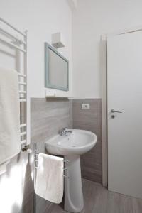 Baño blanco con lavabo y espejo en Casetta con giardino, en Roma