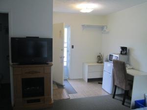a living room with a flat screen tv on a dresser at Edgewater Motel and Campground in Temiskaming Shores