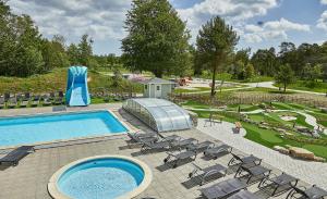 einen Pool mit Stühlen und einer Wasserrutsche in der Unterkunft Sudersand Resort in Fårö