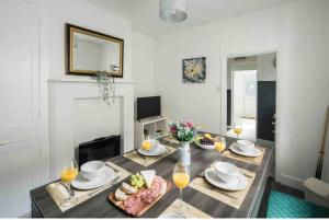 tavolo da pranzo con bicchieri da cibo e vino di Pleasant 4 bed house with x6 beds in heart of Croydon !! - Photo ID & Deposit Required a Croydon