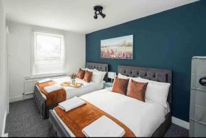una camera con due letti e una parete blu di Pleasant 4 bed house with x6 beds in heart of Croydon !! - Photo ID & Deposit Required a Croydon