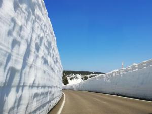 eine Schneemauer an der Seite einer Straße in der Unterkunft Pension Hinode in Hachimantai