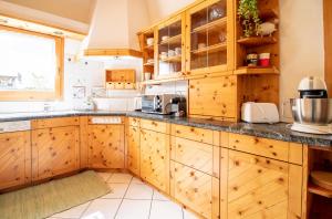 a large kitchen with wooden cabinets and a window at Zentrale Penthouse im Haus Padrun in Arosa